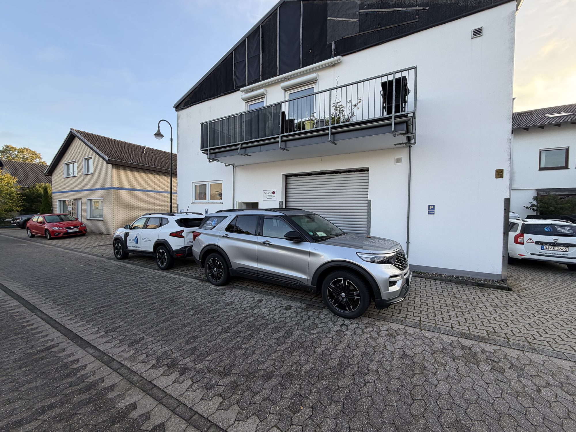 AKOM-Servicefahrzeuge vor dem Bürogebäude der AKOM Facility Services GmbH