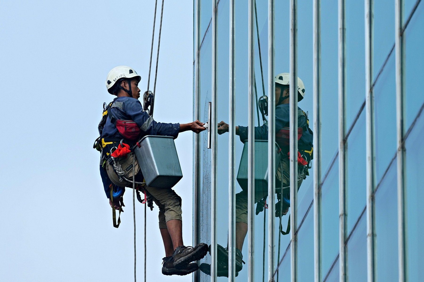 Glasreinigung an einer Glasfassade durch Industriekletterer